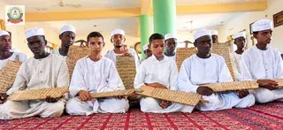 صف من طلاب الخلاوي يحملون ألواحهم.